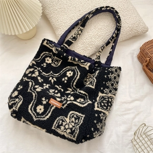 Detailed macro view of the textured lamb wool tote bag with ethnic pattern and leather logo