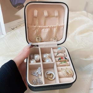 Detail showing inner compartments of a black travel jewelry box for rings and necklaces