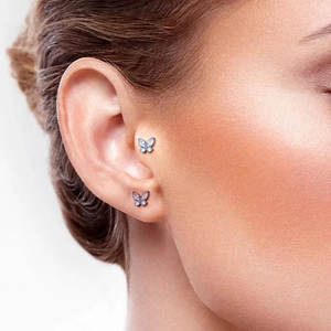 Minimalist G23 titanium butterfly labret stud with blue crystals on ear cartilage
