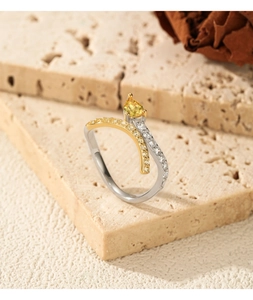 Detail of S925 silver and gold snake ring with yellow pear-cut zircon and pave crystals