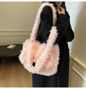 Detail of pink faux fur tote bag with cute animal face embroidery worn by a model