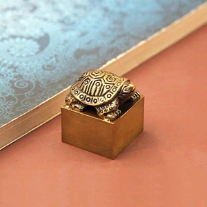 Antique brass turtle statue with geometric patterns on a square base feng shui ornament