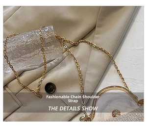 Detail of evening clutch featuring champagne glitter texture and gold chain strap