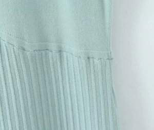 Dettaglio del tessuto a maglia verde chiaro che mostra trame lisce e a costine fini