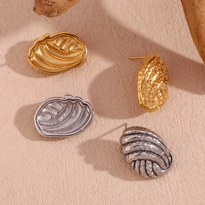 Detail showing 18K gold and silver stud earrings with hammered metal texture design