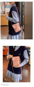 Detail of pink quilted phone bag featuring golden cat-ear clasp and pearl pendant accent