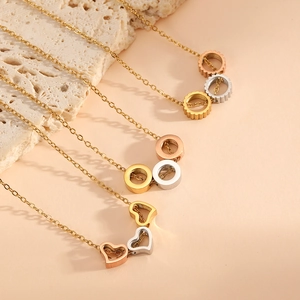 Vue détaillée de pendentifs cœur évidé et engrenage en or, argent et or rose poli
