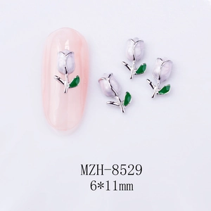 Macro shot of purple tulip nail charms with green leaves and silver metal edges