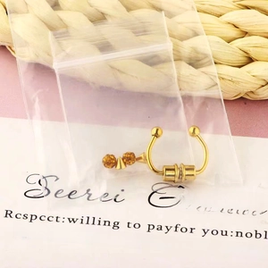 Detailed view of golden magnetic horseshoe fake nose ring with amber beads