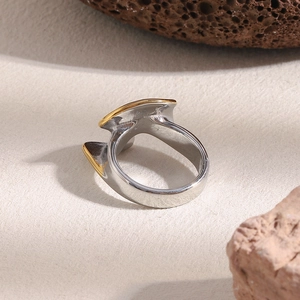 Détail d'une bague torsadée en acier plaqué or 18K sur un support en pierre