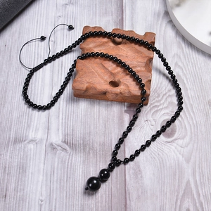 Close-up of adjustable woven black beaded necklace with 16mm natural tiger eye stone pendant
