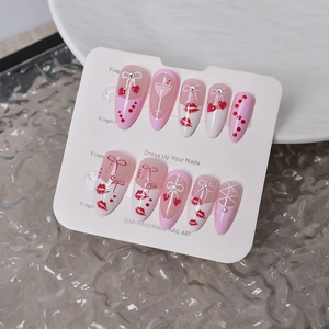 Close-up of heart and bow press-on nails with rhinestones on a display card