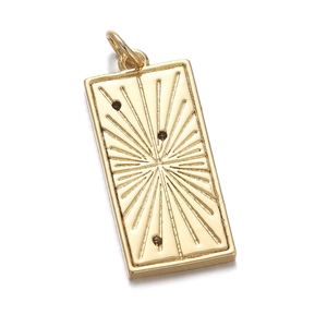 Detailed view of a gold starburst pendant with dark gemstones and polished finish