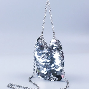 Detailed view of silver sequin mini handbag with elegant metallic chain strap and texture