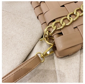 Detail showing the detachable shoulder strap with golden metal lobster clasp and woven texture