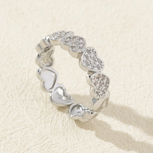 Macro shot of silver heart-shaped ring with pavé-set cubic zirconia and polished finish