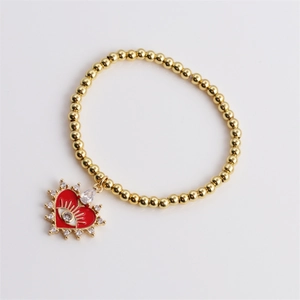Gold plated bead bracelet featuring a red enamel heart pendant with a white eye and crystals