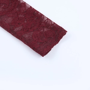 Close-up of wine red lace fabric detail with floral patterns on the sleeve cuff