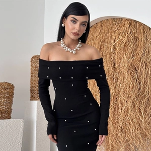 Détail de la robe noire à épaules dénudées ornée de perles blanches élégantes et raffinées