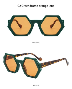 Detail view of hexagonal green frame sunglasses with orange lenses and tortoise temples