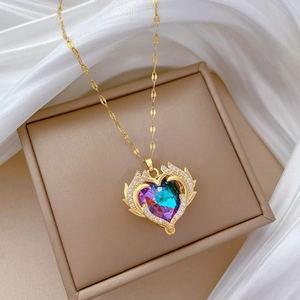 Macro shot of titanium steel heart pendant with colorful crystals and wings on silk