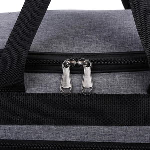 Detail of grey Oxford fabric travel bag with dual silver metal zippers and handles