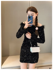 Close-up of black sequined off-shoulder mini dress with elegant feather sleeves