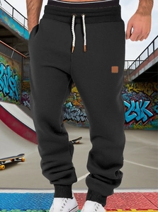 Close-up of black jogger pants featuring drawstring waist and side patch detail