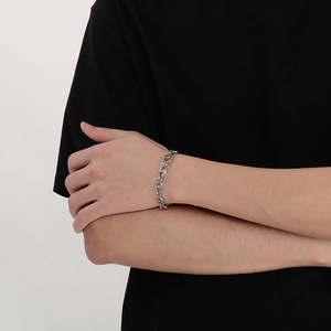 Detail of silver pig nose anchor link stainless steel bracelet on model's wrist