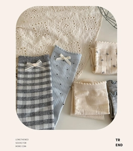 Detail of assorted blue and beige knit socks with cute bow accents and floral patterns