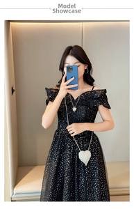 Close-up of heart-shaped glitter chain bag paired with a black sequin off-shoulder dress