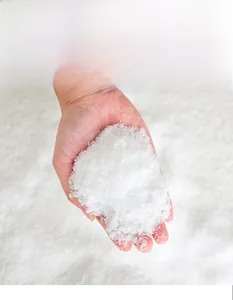 Gros plan de poudre de neige artificielle pour sapin de Noël tenue dans les mains