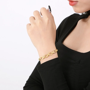Close-up of gold hexagonal link chain bracelet on wrist featuring minimalist metal design