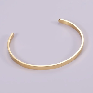 Detailed view of a minimalist 18k gold-plated stainless steel open cuff bracelet