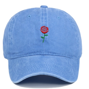 Close-up of red rose embroidery on blue washed cotton baseball cap with vintage texture