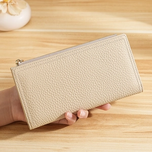 Beige litchi grain leather long wallet for women with golden zipper in hand