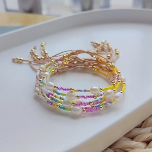 Detail of bohemian handmade bracelets with freshwater pearls and colorful miyuki beads