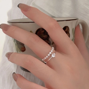 Detail of 925 sterling silver layered rings with sparkling cubic zirconia on female hand