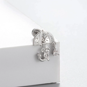 Silver umbrella stud earring with bow detail and teardrop zircon pendant on white display