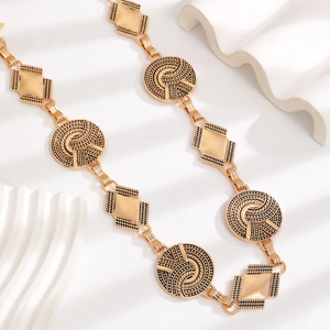 Detail of vintage bohemian gold waist chain with embossed spiral and diamond motifs