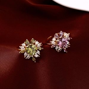 Detailed macro of 14k gold plated flower ring with heart-shaped zircon on red silk