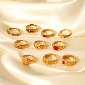 Golden vintage ring set with red gems and boho sun motifs on cream satin fabric