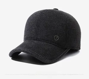 Detail of grey wool baseball cap with metal F logo badge and textured winter fabric