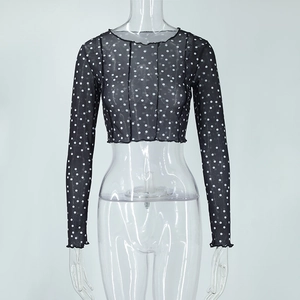 Detail of sheer black mesh crop top with white polka dots and lettuce trim edges