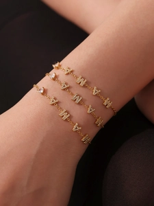 Gros plan d'un ensemble de bracelets dorés avec zircons en forme de cœur et triangle
