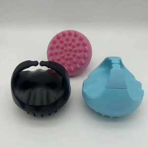 Detailed view of silicone scalp massager brushes in black, blue, and pink colors