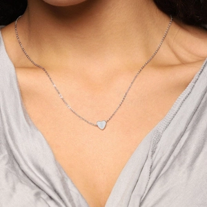 Elegant stainless steel heart pendant necklace with engraved letter E worn by a model