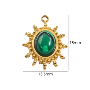 Detailed view of vintage gold sun flower pendant with green gemstone 18mm by 13.5mm