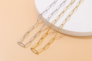 Detail of silver and gold sparkling textured oval link necklaces on a white display