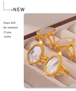 Detailed macro of irregular 18k gold plated rings with white shell inlays on velvet tray
